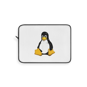 May include: A white rectangular laptop sleeve featuring a centred graphic of a black and white penguin with a yellow beak and yellow feet. The sleeve has a black zip closure along the side and a clean, minimalist white fabric surface.
