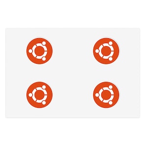 Op de afbeelding: Een wit rechthoekig vel met vier ronde stickers gerangschikt in een twee-bij-twee raster. Elke sticker is oranje met een wit Ubuntu-logo, bestaande uit drie gestileerde figuren die in een cirkel rond een open ruimte zijn verbonden.