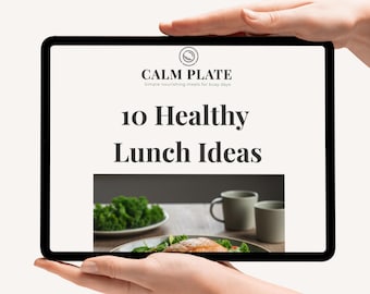 May include: A tablet displays the text "CALM PLATE" and "10 Healthy Lunch Ideas." The image shows a plate of food, a plate of greens, and two mugs. The tablet is held by two hands.