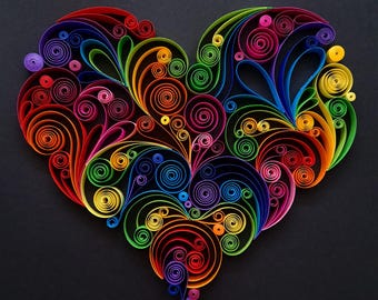 May include: A colorful heart-shaped paper quilling art piece. The design features tightly coiled paper strips in a rainbow of colors, including red, orange, yellow, green, blue, and purple, arranged on a black background.