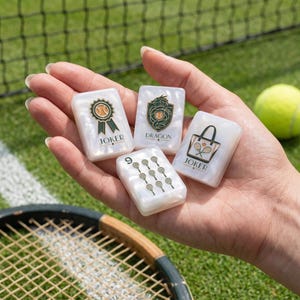 May include: Four rectangular white tiles with a pearlescent finish. One tile features a green ribbon award with the text JOKER. Another shows a green dragon crest with the text DRAGON. A third displays a tote bag with tennis rackets and the text JOKER. The fourth tile shows the number 9 with nine small tennis racket icons.