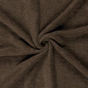 May include: A dark brown fabric with a soft, plush, and fuzzy texture. The material is gathered in the center, creating natural folds and ripples that radiate outward, highlighting the dense, short pile surface of the textile material.