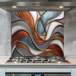 Puede incluir: Un protector contra salpicaduras de cocina decorativo con un diseño abstracto de formas fluidas y en capas. La paleta de colores incluye tonos de cobre, gris, blanco y azul, con ribetes dorados. El protector contra salpicaduras está instalado sobre una encimera de gas.