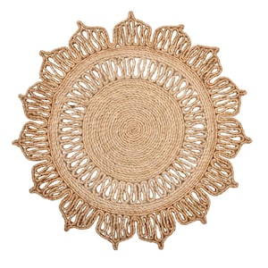 May include: A round, natural jute rug with a sunflower design. The rug features a central spiral pattern, an openwork middle ring, and a scalloped outer edge. The rug is made of woven jute fibers and is a neutral tan color.