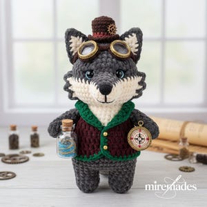 Può includere: Bambola a uncinetto a forma di lupo con cappello a cilindro marrone, occhiali e gilet. Il lupo tiene in mano una piccola bottiglia con dettagli blu e oro e una bussola. Tema steampunk.