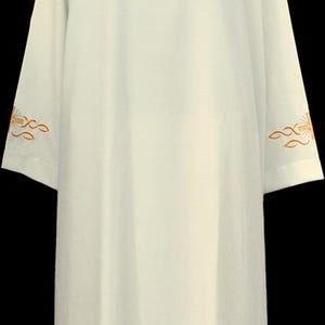 May include: Cream-coloured liturgical alb with a high neckline and long sleeves. The sleeves and hem feature embroidered gold crosses and wave patterns. The alb is displayed on a black mannequin.