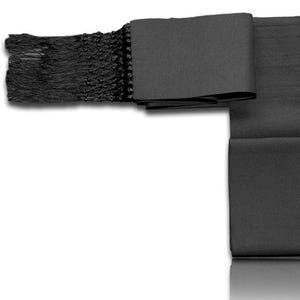 Puede incluir: Un cinturón obi negro, una faja japonesa tradicional, se muestra sobre un fondo blanco. El cinturón está hecho de una tela oscura con un extremo con flecos y está doblado en forma rectangular. El obi se utiliza para asegurar un kimono.
