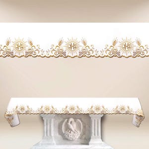 May include: White altar cloth with gold embroidered border featuring sunbursts, wheat, grapes, and the letters IHS. The cloth is draped over a marble altar with a carved pelican. The design is symmetrical and ornate.