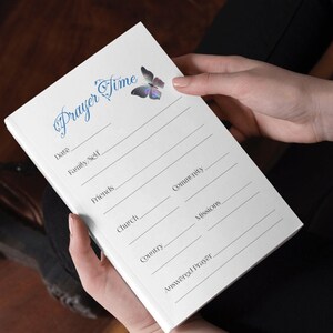 May include: A white prayer journal with a blue butterfly design. The journal has sections for prayer requests for family, self, friends, church, community, missions, country, and answered prayers.