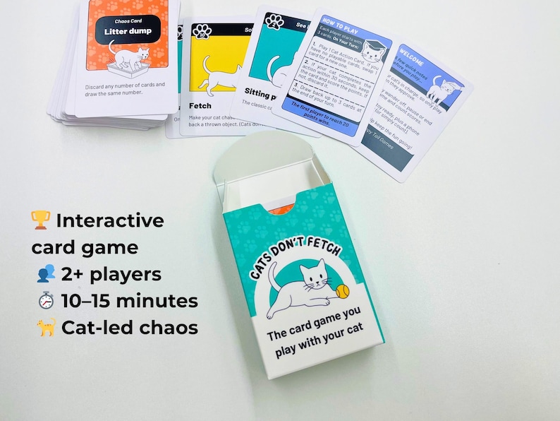 May include: A card game titled Cats Don't Fetch with a teal and white box featuring a white cat illustration. The set includes a deck of cards with various cat-themed instructions, including a Chaos Card labeled Litter dump and a How to Play card.
