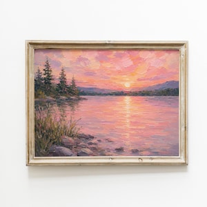 Peut inclure: Une peinture à l'huile dans un cadre en bois clair représentant un coucher de soleil sur un lac. La scène montre des nuages roses et orange, un soleil brillant, des pins vert foncé sur la rive gauche et un terrain rocheux au premier plan.