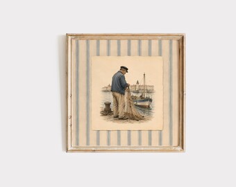 May include: Framed vintage print depicting a fisherman on a pier, mending his net. The artwork features a man in a blue jacket and cap, a boat, and a lighthouse in the background. The frame has a striped pattern.