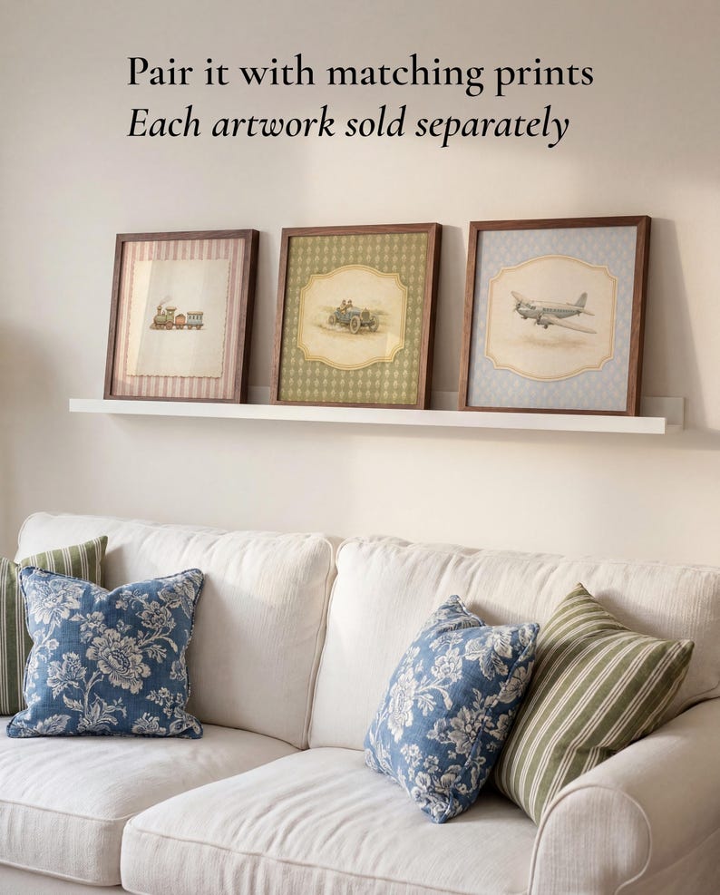 May include: Three framed artworks with vintage transportation illustrations: a train, a car, and an airplane. The frames are dark wood, and the prints have a soft, aged appearance. The artworks are displayed above a white couch with blue floral and green striped pillows.
