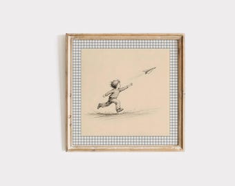 May include: A framed wall art print featuring a black and white ink sketch of a child running and reaching toward a paper airplane. The artwork is set against a light beige background and enclosed within a border of grey and white gingham pattern.