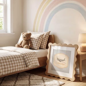 May include: A child's bedroom with a wooden bed, featuring a gingham patterned comforter and pillows. A brown teddy bear sits on the bed. A framed picture of an airplane rests on the floor. A rainbow is painted on the wall.