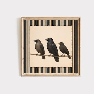 May include: A square framed wall art piece featuring a vintage-style illustration of three black birds perched on a thin branch. The central image has a scalloped edge and is set against a background of vertical black and beige stripes.