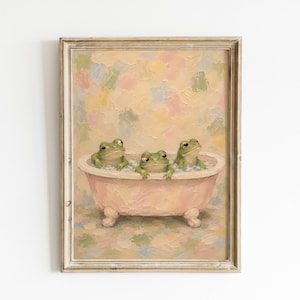 Pode incluir: Uma pintura a óleo emoldurada com três sapos verdes sentados numa banheira de pés de garra cor-de-rosa clara cheia de bolhas brancas. O fundo consiste em pinceladas pastel suaves e misturadas em tons de amarelo, rosa, azul e verde.