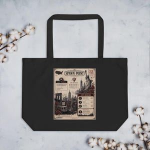 Op de afbeelding: Zwarte draagtas met een vintage-stijl New York City-kaart met de tekst "Spawn Point". Het ontwerp bevat het Vrijheidsbeeld, de skyline en rozen. De tas heeft lange handvatten.