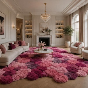Könnte beinhalten: Ein großer, flauschiger Teppich mit einem strukturierten, kreisförmigen Muster in verschiedenen Rosa-, Magenta- und Dunkellila-Tönen. Der Teppich bedeckt einen großen Teil des Bodens in einem Wohnzimmer mit Sofa, Sesseln und Kamin.
