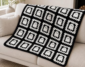 May include: A black and white crochet blanket featuring a repeating pattern of square motifs. Each square contains a white ghost figure centered within a white crocheted border, all joined together to form a large, rectangular textile throw.