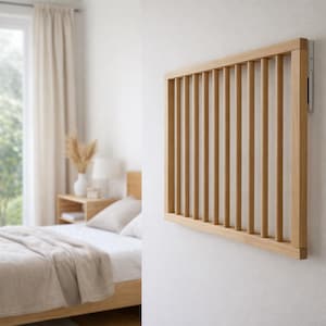 Peut inclure: Une tête de lit en bois clair, fixée au mur, avec des lattes verticales. La tête de lit est rectangulaire et fixée sur un mur blanc. La chambre comprend un lit avec une couverture et des oreillers beiges, et une table de chevet avec une lampe.