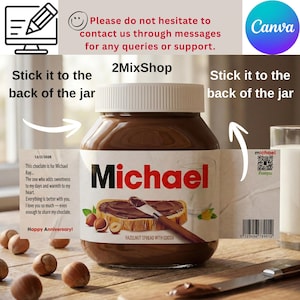 Peut inclure: Un pot de pâte à tartiner aux noisettes et au cacao, étiqueté "Michael" en rouge. L'étiquette comprend un message, un code QR et le texte "Happy Anniversary !" Le pot est sur une surface en bois avec des noisettes.