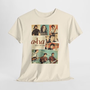 Puede incluir: Camiseta color crema con un gráfico retro de la banda a-ha. El diseño incluye a los miembros de la banda en un estilo de cómic, con el nombre de la banda y el título de la canción "take on me" en una fuente vintage. Una camiseta con temática musical.