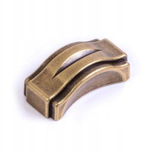 Può includere: Una maniglia per mobili curva color bronzo, con base rettangolare. La maniglia presenta un design a onda con una scanalatura centrale. Il metallo ha un aspetto leggermente invecchiato, che suggerisce uno stile vintage o antico. Per cassetto o armadio.