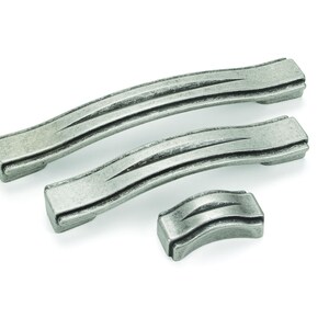 May include: Three antique-style cabinet pulls in a weathered silver finish. Two are curved handles, and one is a smaller, rectangular knob. Each features three parallel grooves, adding a textured detail to the hardware.