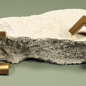 Może przedstawiać: Zestaw trzech ceramicznych kubków z nakrapianym, matowym wykończeniem. Kubki są w odcieniach kremowym, jasnoszarym i ciemnoszarym. Każdy kubek ma prosty, minimalistyczny design, idealny do kawy lub herbaty.