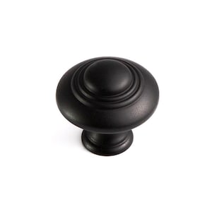 Può includere: Un pomello nero per mobili con un design rotondo e stratificato. Il pomello ha una finitura opaca e una base corta e cilindrica. Adatto per cassetti e armadi.
