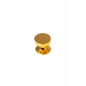 May include: A gold-colored cabinet knob with a round top and base, connected by a shorter, faceted stem. The hardware has a shiny, reflective surface, and is set against a plain white background.