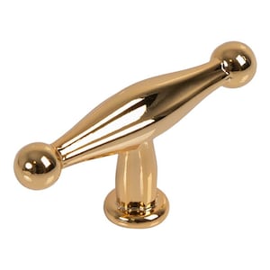 Könnte beinhalten: Ein goldfarbener Schrankgriff mit einem unverwechselbaren Design. Der Griff hat einen länglichen Mittelteil mit abgerundeten Enden und einen Stützfuß. Die Hardware besteht aus einem glänzenden, reflektierenden Material und verleiht jedem Möbelstück einen Hauch von Eleganz.