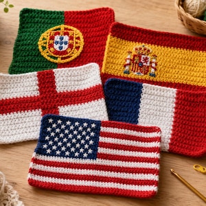Op de afbeelding: Vijf rechthoekige gehaakte stukken met de nationale vlaggen van Portugal, Spanje, Engeland, Frankrijk en de Verenigde Staten. Elke vlag is gemaakt met garen in de bijbehorende kleuren, inclusief de gedetailleerde emblemen op de vlaggen.