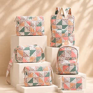 Puede incluir: Una colección de bolsos acolchados con un diseño de patchwork de triángulos de tela floral, rosa sólido y cuadros verdes. El conjunto incluye una funda rectangular para portátil, dos mochilas, dos bolsos cruzados y un pequeño estuche rectangular con cremallera.