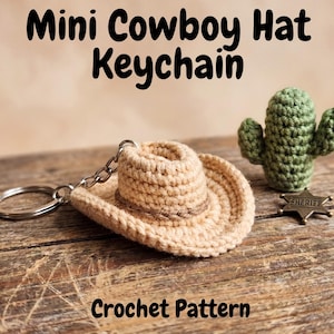 Peut inclure: Un porte-clés mini chapeau de cowboy crocheté beige avec une bande marron, un cactus vert et un badge de shérif. Le texte "Mini Cowboy Hat Keychain" et "Crochet Pattern" est affiché.