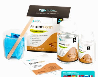 May include: Artline Epoxy Resin kit with "Artline Honey" label. Includes two bottles, a mixing cup with blue gloves, a wooden mixing stick, and a box. The kit is designed for resin art and geode art projects. The kit includes a multi-language instruction manual.