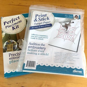 May include: A Perfect Placement Kit and a package of Print & Stick Target Paper for inkjet and laser printers. The packaging features text, a barcode, and an illustration of a sewing machine needle stitching a geometric pattern on white fabric.