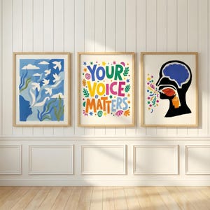 Könnte beinhalten: Drei gerahmte Kunstdrucke mit Holzrahmen. Der linke Druck zeigt ein blau-weißes abstraktes Design mit Vögeln. Der mittlere Druck sagt "YOUR VOICE MATTERS" in bunten Buchstaben. Der rechte Druck zeigt eine schwarze Silhouette eines Kopfes mit Gehirn und farbenfroher Sprache.