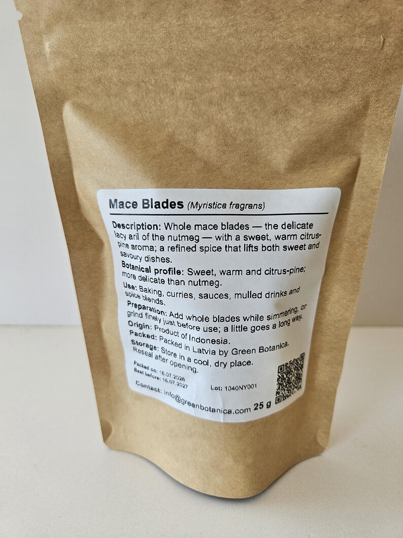 K&ouml;nnte beinhalten: Ein brauner Papierbeutel mit 25 g Muskatbl&uuml;ten (Myristica fragrans). Das wei&szlig;e Etikett enth&auml;lt eine detaillierte Produktbeschreibung, ein botanisches Profil, Anwendungshinweise, Herkunft, Lagerung, einen QR-Code und Kontaktinformationen.