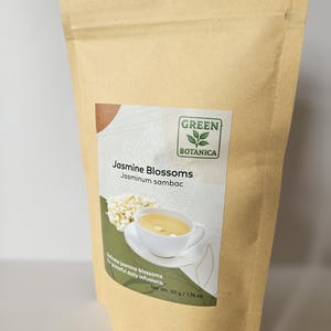 Peut inclure: Une tasse en c&eacute;ramique blanche avec une anse noire et le texte "But First, Coffee" en gras noir. La tasse est pos&eacute;e sur un fond flou. La tasse mesure environ 10 cm de hauteur.
