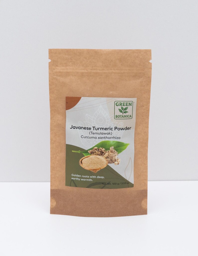 Op de afbeelding: Een bruine papieren zak met Javaans kurkumapoeder. Het etiket bevat de tekst "Green Botanica" en "Javanese Turmeric Powder (Temulawak) Curcuma xanthorrhiza". Het etiket bevat ook een illustratie van kurkumawortels en -poeder.