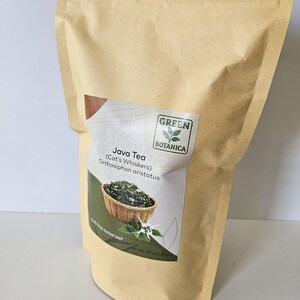 K&ouml;nnte beinhalten: Ein beigefarbener Papierbeutel mit Java-Tee, auch bekannt als Katzenbart oder Orthosiphon aristatus. Das Etikett zeigt das Green Botanica-Logo, ein Bild von getrockneten Bl&auml;ttern in einem Korb und ein Nettogewicht von 50 g.