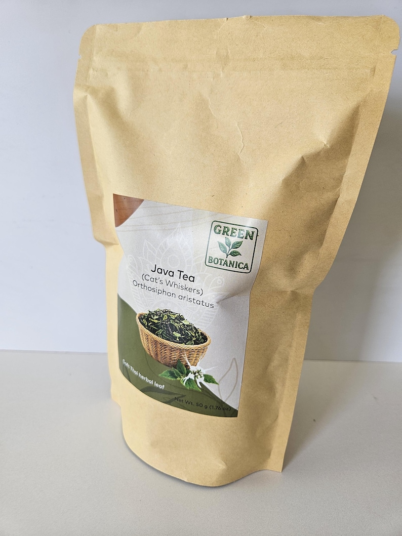 K&ouml;nnte beinhalten: Ein beigefarbener Papierbeutel mit Java-Tee, auch bekannt als Katzenbart oder Orthosiphon aristatus. Das Etikett zeigt das Green Botanica-Logo, ein Bild von getrockneten Bl&auml;ttern in einem Korb und ein Nettogewicht von 50 g.