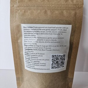 K&ouml;nnte beinhalten: Ein brauner Papiert&uuml;te mit fein gemahlenem Basilikumblattpulver. Das Etikett beschreibt das aromatische Kr&auml;uterprofil, den pfeffrigen Abgang und die Verwendung in Suppen, Currys und Saucen. Die T&uuml;te enth&auml;lt auch Zubereitungshinweise und einen QR-Code.