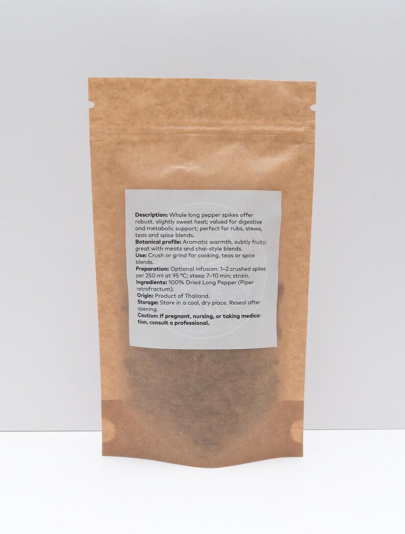 Peut inclure: Un sachet debout en papier kraft brun contenant des &eacute;pis de poivre long s&eacute;ch&eacute;s. Une &eacute;tiquette rectangulaire blanche sur le devant fournit des d&eacute;tails sur le produit, notamment la description, le profil botanique, la pr&eacute;paration et l'origine.