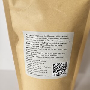 Peut inclure: Un sac en papier brun avec une &eacute;tiquette blanche d&eacute;crivant les fleurs de jasmin. L'&eacute;tiquette d&eacute;taille l'ar&ocirc;me floral, l'utilisation dans les tisanes et les instructions de pr&eacute;paration. Un code QR est &eacute;galement visible.