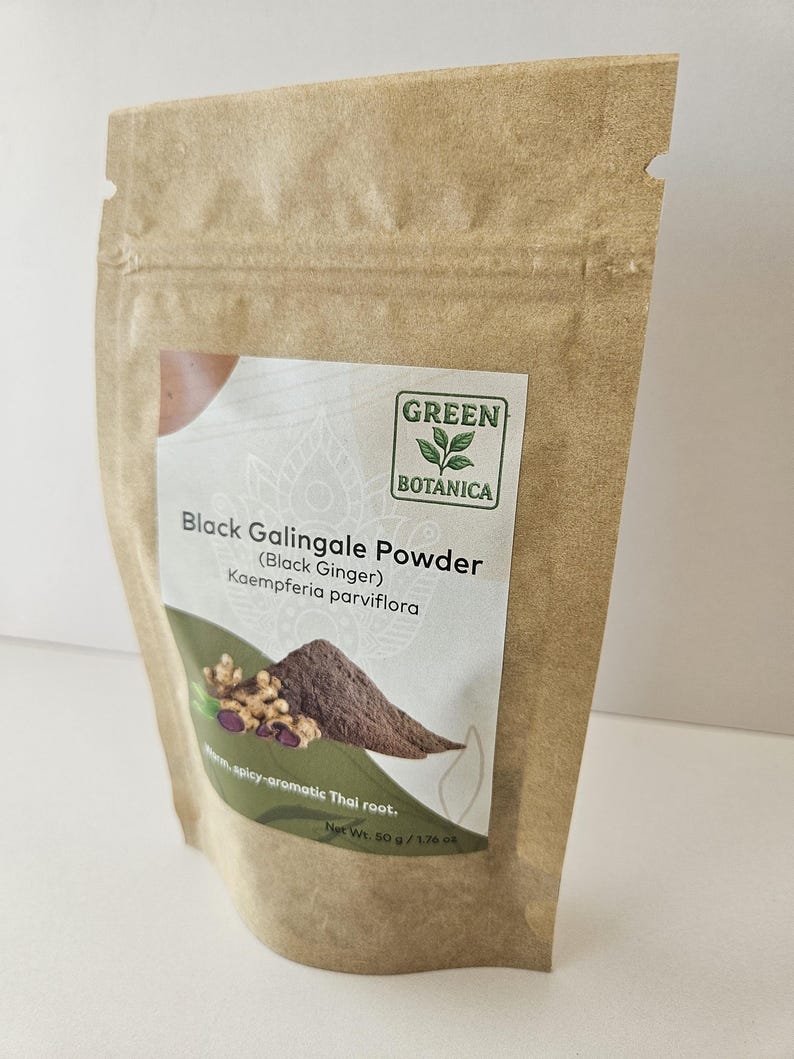 Może przedstawiać: Brązowa torebka stojąca z papieru kraftowego zawierająca sproszkowany czarny galgant. Etykieta zawiera logo Green Botanica, tekst Black Galingale Powder (Black Ginger) Kaempferia parviflora, obraz korzenia i proszku oraz napis Net Wt. 50 g.