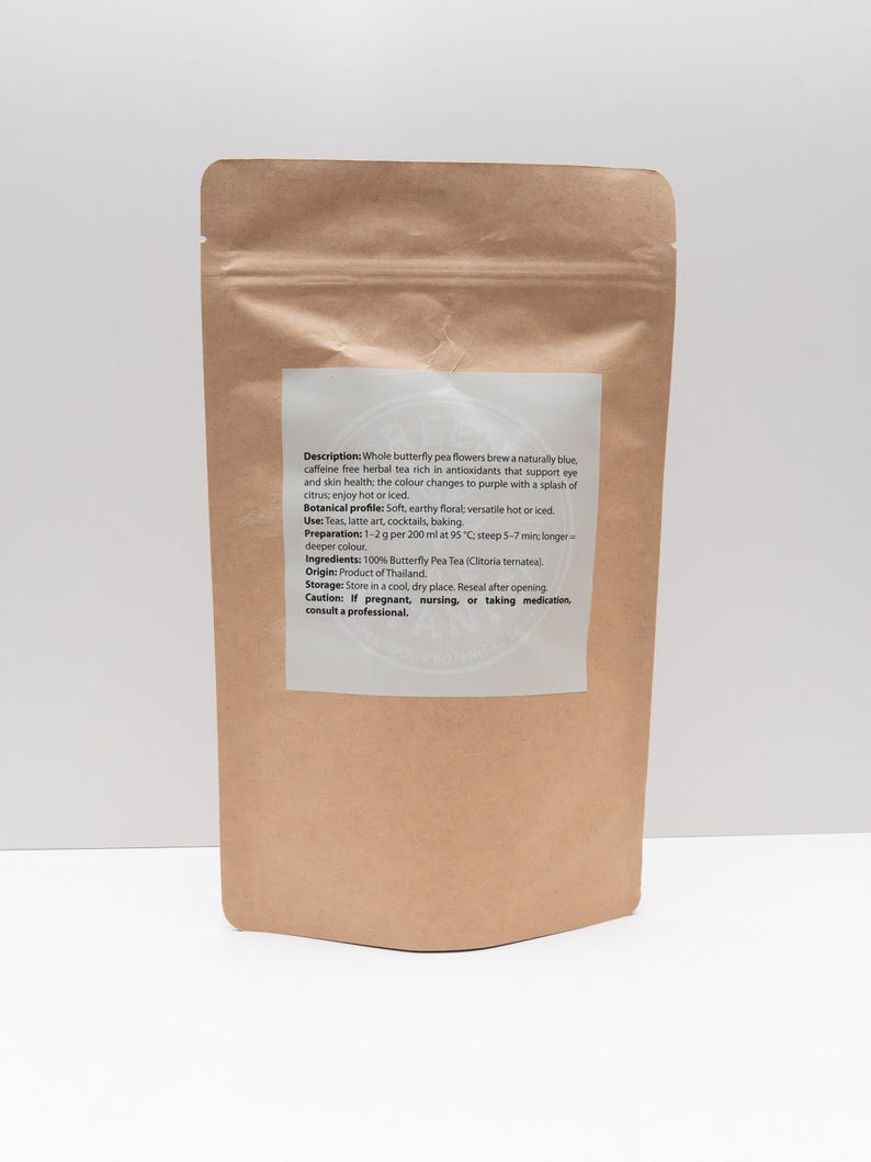 Pode incluir: Uma bolsa de papel castanho contendo flores de feij&atilde;o-borboleta. O r&oacute;tulo branco cont&eacute;m o texto: Description: Whole butterfly pea flowers brew a naturally blue, caffeine free herbal tea rich in antioxidants. Botanical profile: Soft, earthy floral; versatile hot or iced. Use: Teas, latte art, cocktails, baking. Preparation: 1-2 g per 200 ml at 95 &deg;C; steep 5-7 min. Ingredients: 100% Butterfly Pea Tea (Clitoria ternatea). Origin: Product of Thailand. Storage: Store in a cool, dry place. Caution: If pregnant, nursing, or taking medication, consult a professional.