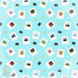 May include: A repeating pattern on a light blue background featuring polaroid-style images with various illustrations, including cats, landscapes, and night scenes. Small black cameras and yellow starbursts are scattered throughout the design.